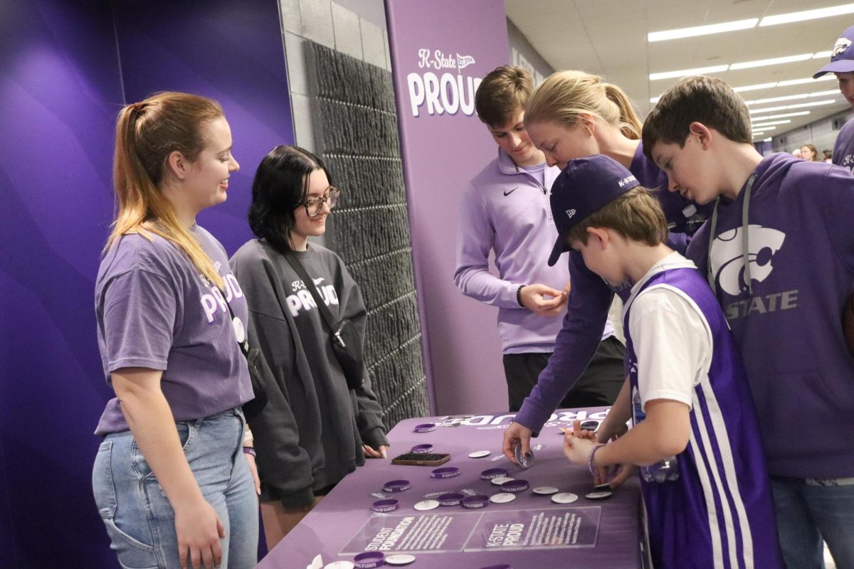 Juniors Abby Collins and Abigail Marshall greet Wildcat fans at the K-State Proud table. K-State Proud is led by the K-State Student Foundation and raises money to help students continue their education. 