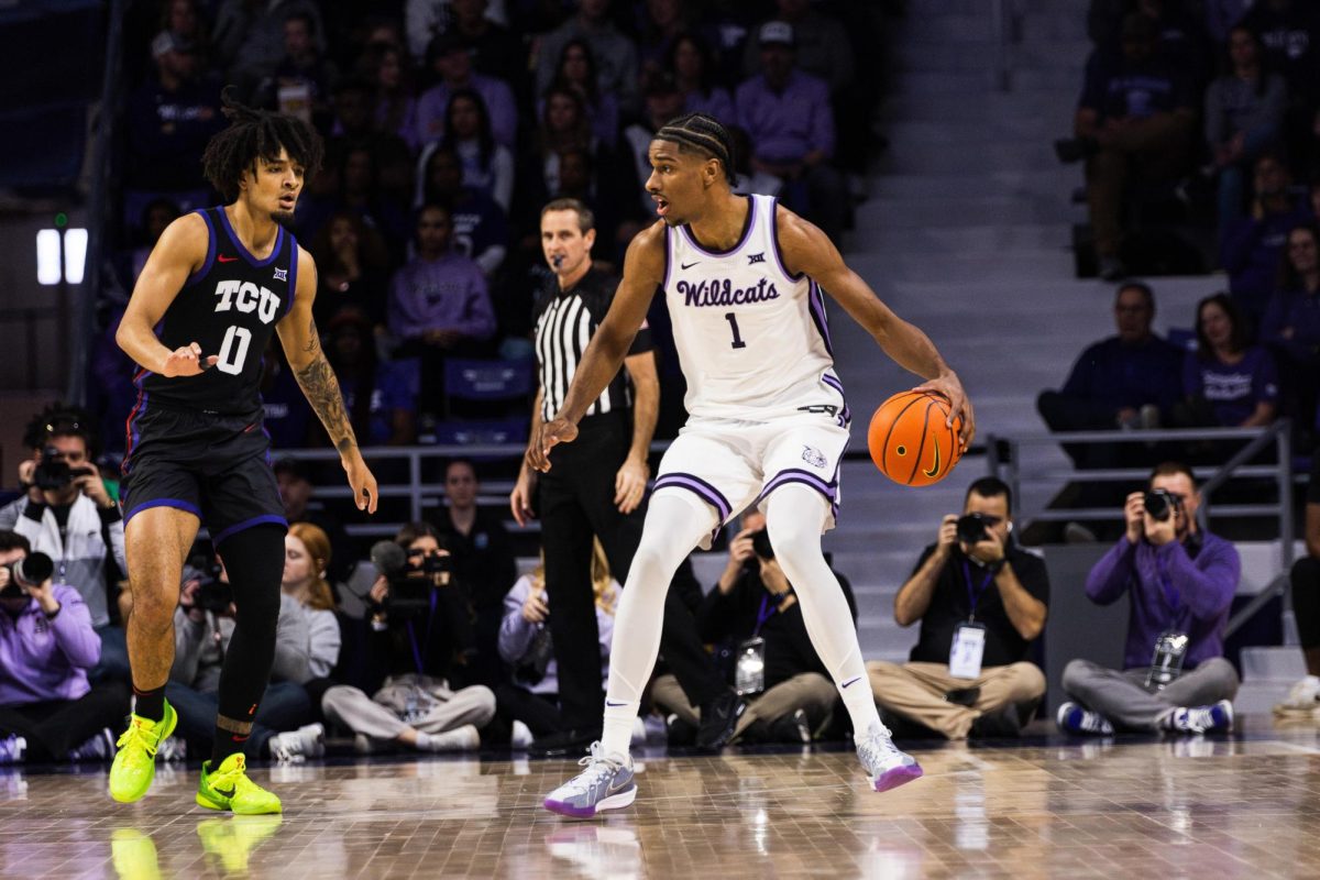 Senior David NGuessan moves the ball away from the TCU defense. K-State lost to the TCU Horned Frogs with a final score of 75-72 following a game-winning 3-point shot on Feb. 17 at Bramlage Coliseum.