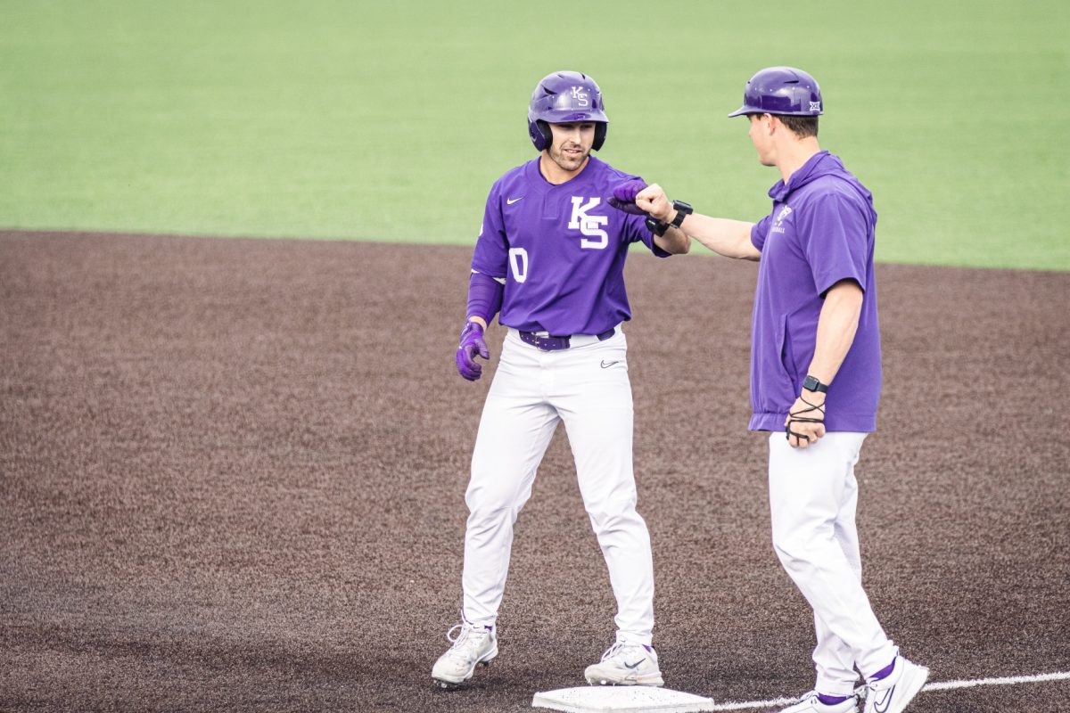 Infielder Jayden Parsons fists bumps the first base coach in the game against South Dakota State. The Wildcats defeated the Jackrabbits 16-5 on March 13 at Tointon Family Stadium.