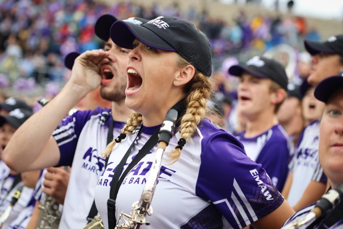 Yelling out the words, saxophone player Kennedy Mounce cheers on the wildcats during a fall 2022 football game. 