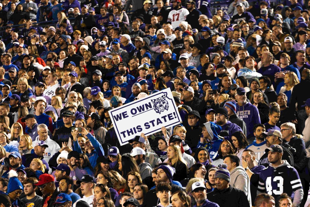 Kansas State fans hold up a We Own This State sign at the K-State vs. Kansas football game. The Wildcats beat the Jayhawks 31-27 on Nov 18. at David Booth Kansas Memorial Stadium.