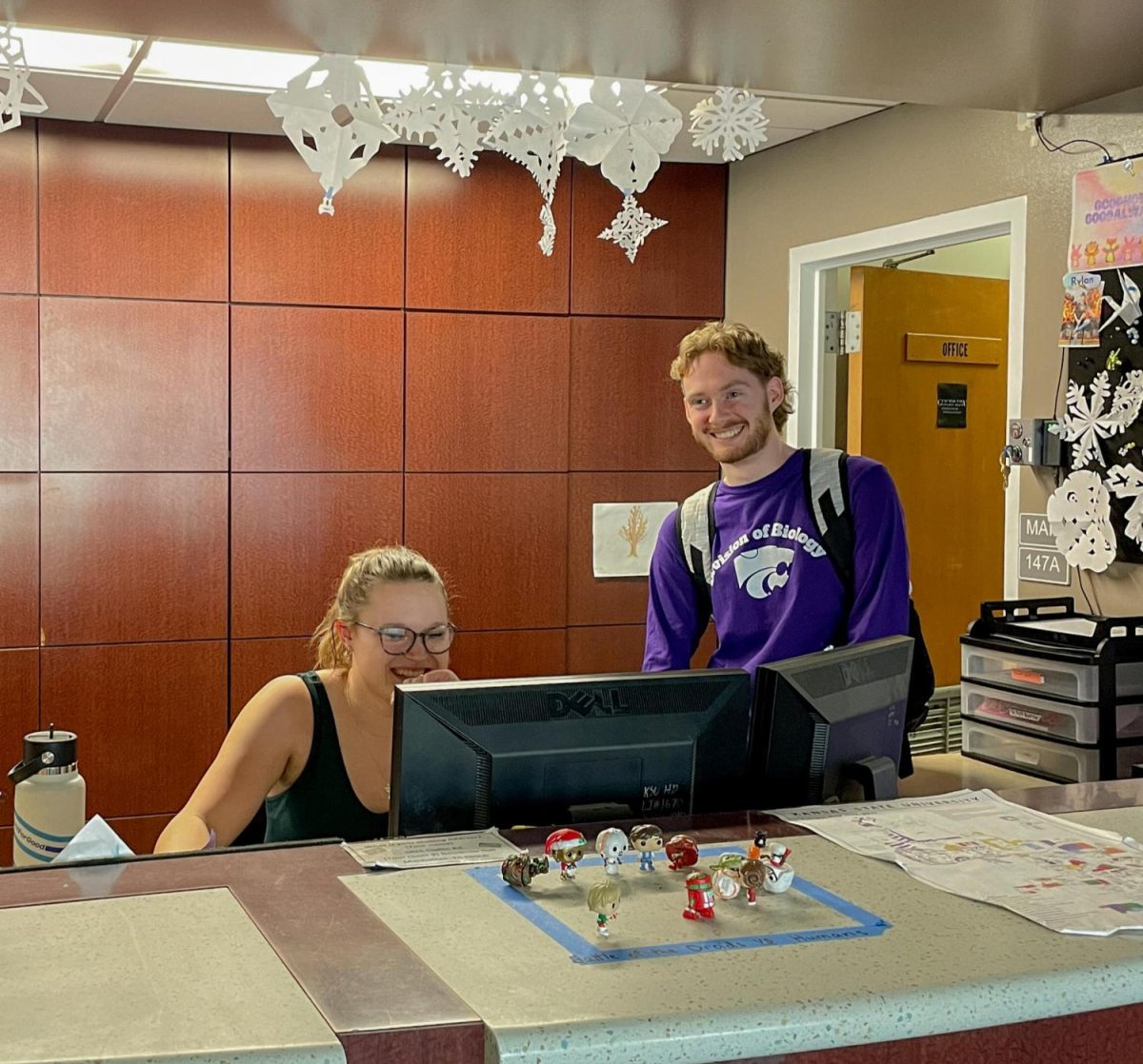 While working at the front desk of Goodnow Hall, two Resident Assistants converse. Goodnow Hall is one dorm option for on-campus living.
