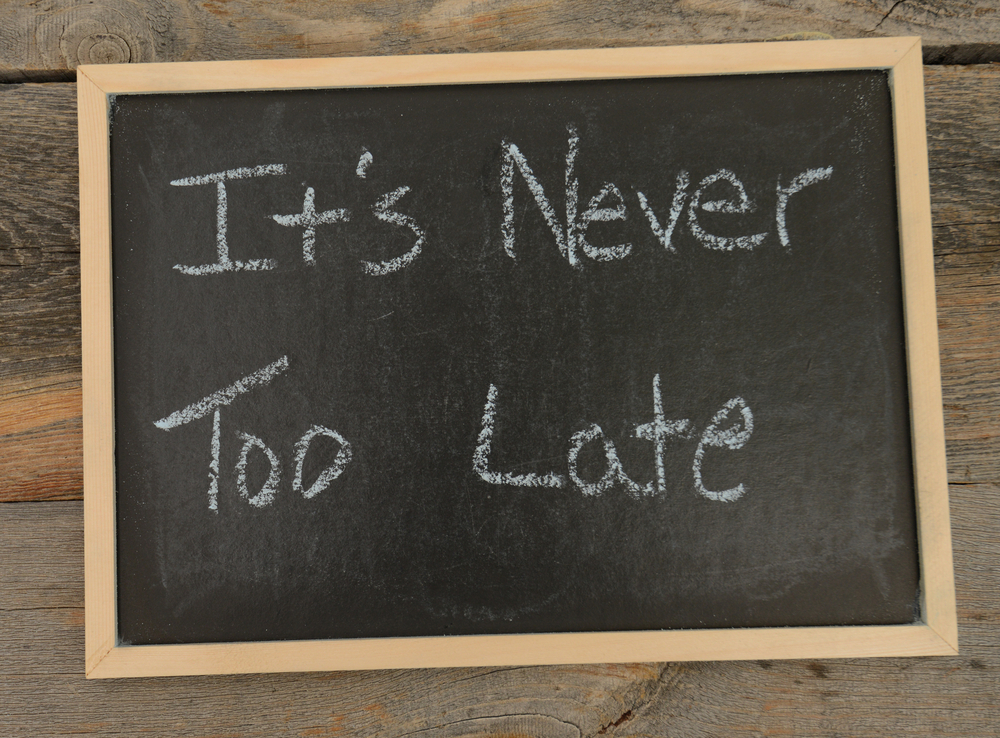 Its never too late written in chalk on a chalkboard on a rustic background
