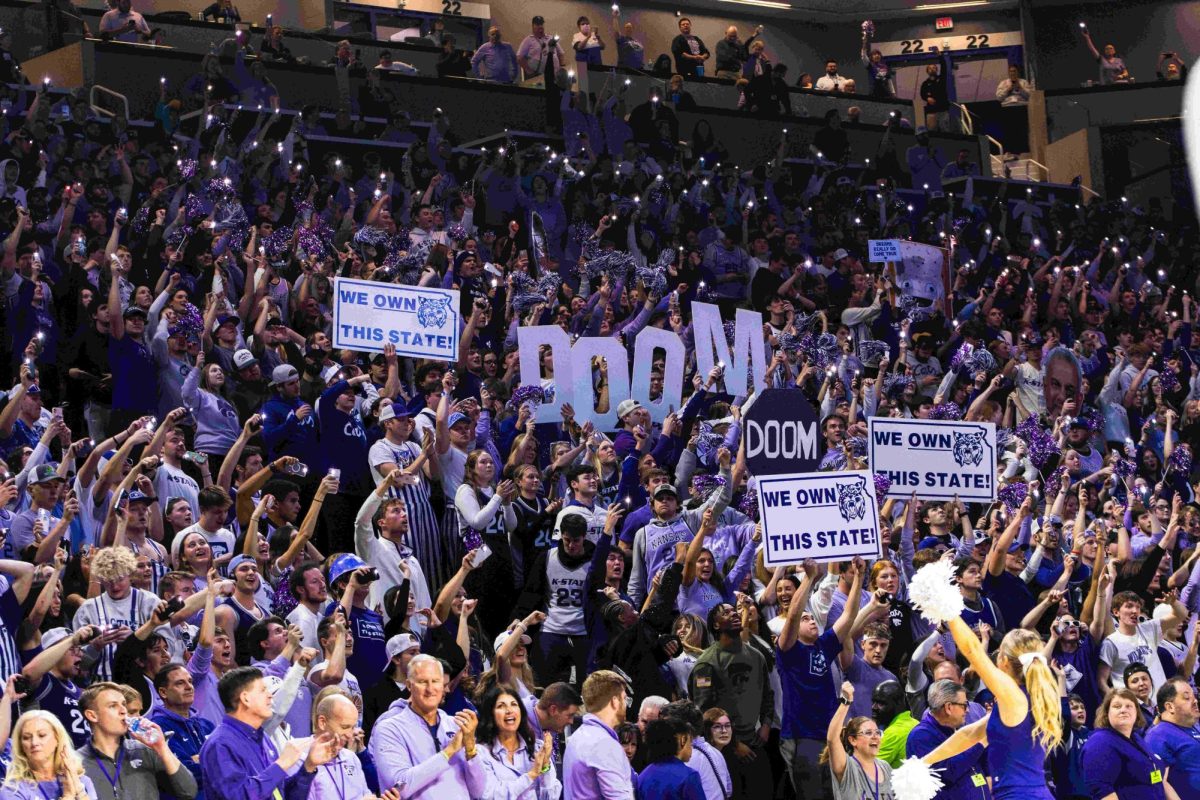 K-State students and fans hold up signs and flashlights as they jump to Sandstorm during a timeout against No. 4 Kansas. The Wildcats took the Jayhawks into overtime, resulting in a win of 75-70 Feb. 5 in Bramlage Coliseum. 