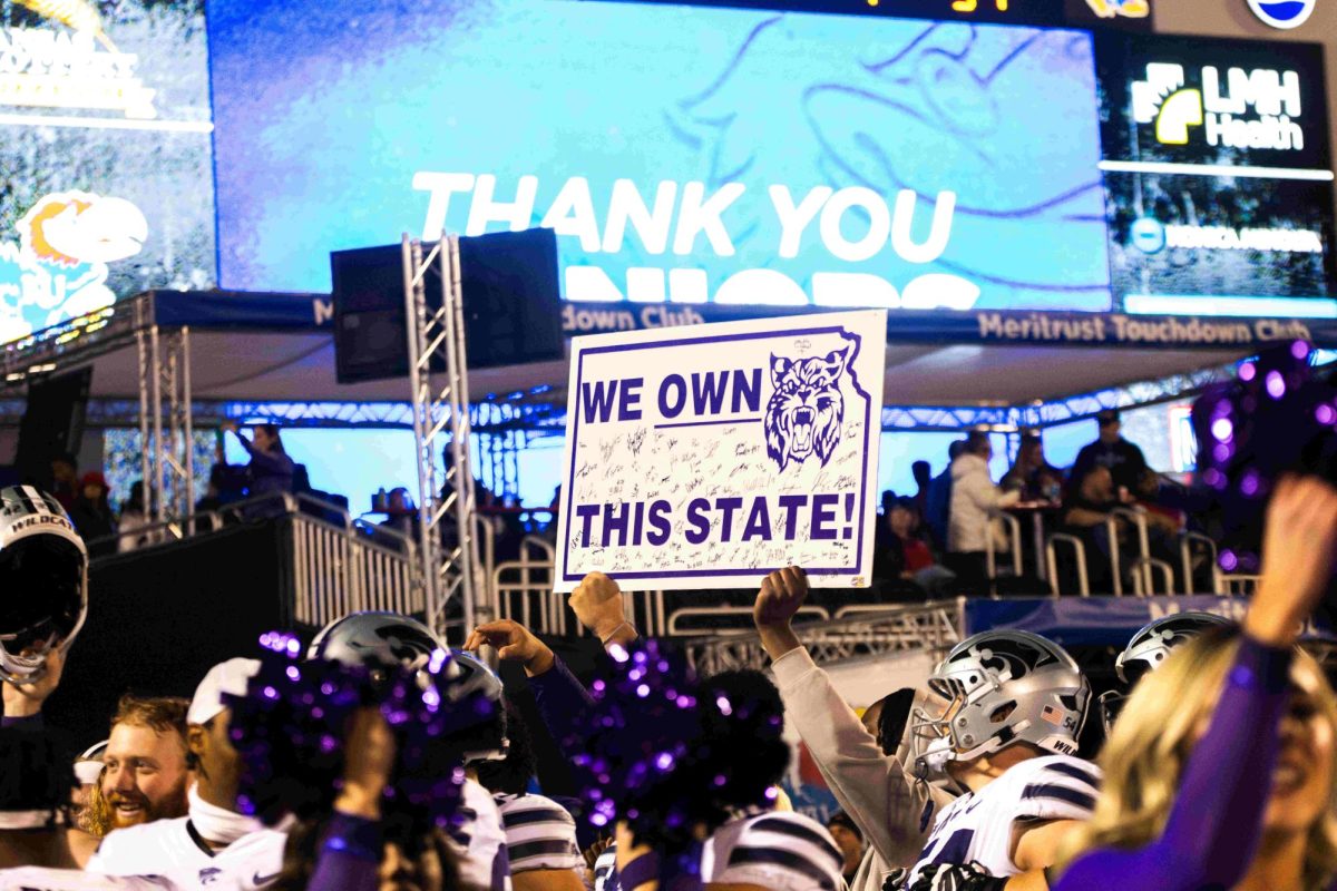 K-State players hold up a We Own This State sign following the 31-27 win over the Kansas Jayhawks Nov. 18 at David Booth Kansas Memorial Stadium. 