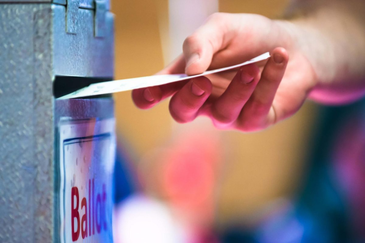 A voter drops his ballot into the ballot box at the Riley County Republican Party Presidential Caucus Mar. 5, 2016, at Manhattan High School. 