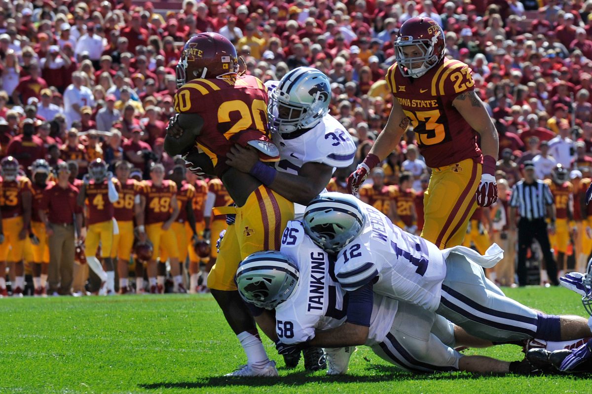 Linebacker Dakorey Johnson, wide receiver Stanton Weber and linebacker Trent Tanking piling on Iowa State running back DeVondrick Nealy at Jack Trice Stadium on Sept. 6, 2014. The Wildcats defeated the Cyclones 32-38.