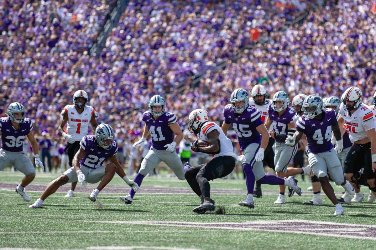 Defenders Marques Sigle (21) and, Austin Moore (41) and Austin Romaine (45) swarm a Cowboy during K-State's 42-20 win over Oklahoma State on Sept. 28.