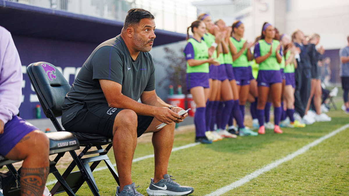 K-State head soccer coach Mike Dibbini sits on the sideline during at game at Buser Family Park. Dibbini stepped down as head coach after the 2024 season. (Photo courtesy of K-State Athletics) 