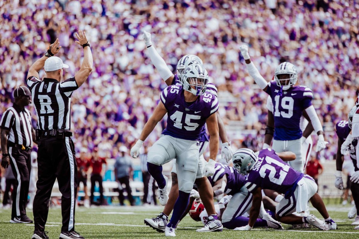 Linebacker Austin Romaine celebrates with teammates after completing a big tackle. The Kansas State Wildcats defeated Troy University 42-13 on Sept. 9 at Bill Snyder Family Stadium. 