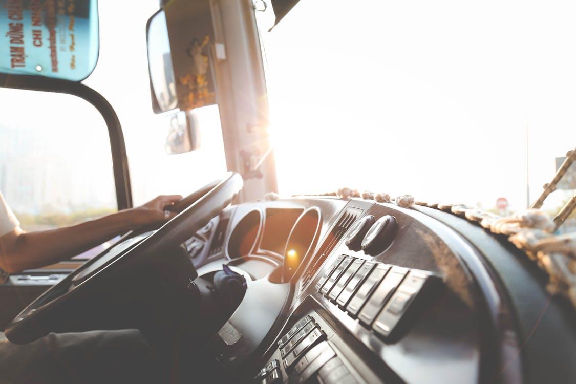 Free A bus driver navigating the city streets during a sunny day, focusing on the road. Stock Photo