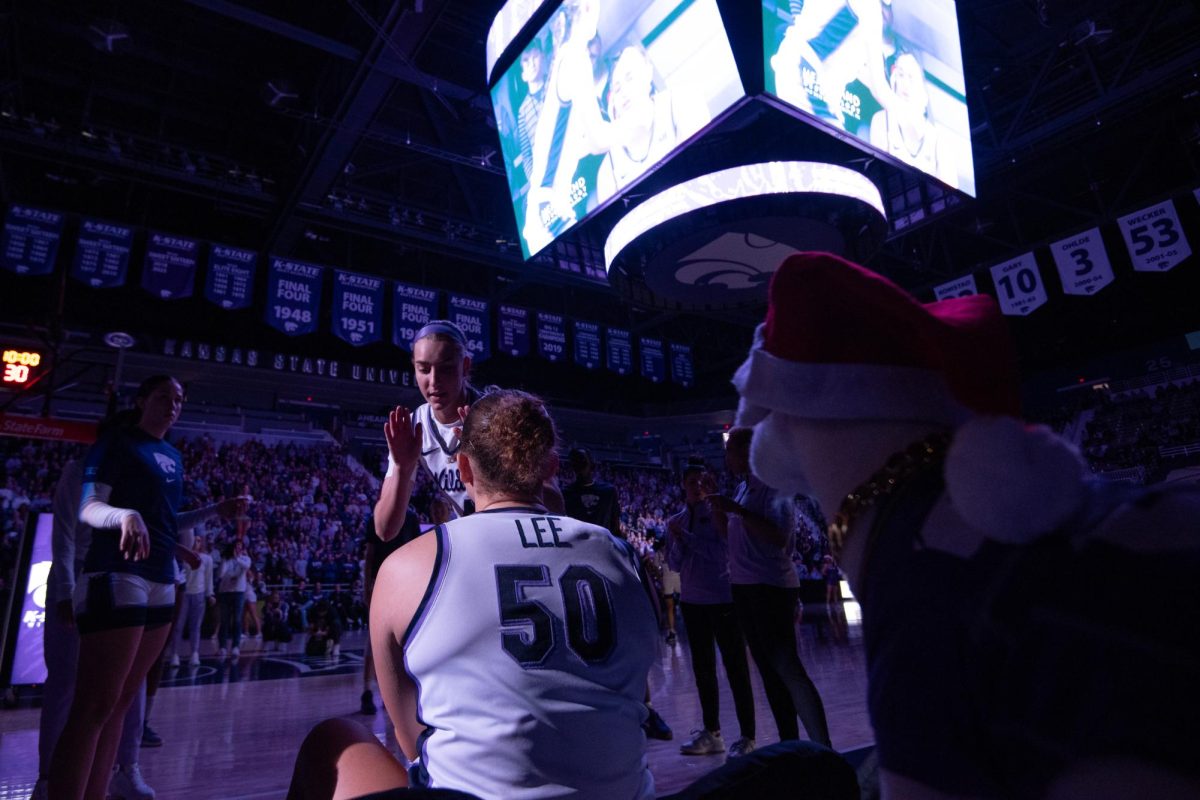 K-State's star center Ayoka Lee waits for her name to be called during pregame introductions against the Cincinnati Bearcats on Dec. 22. Looking over Lee is Gap Goat with a Santa hat as K-State entered Christmas break with a win. 