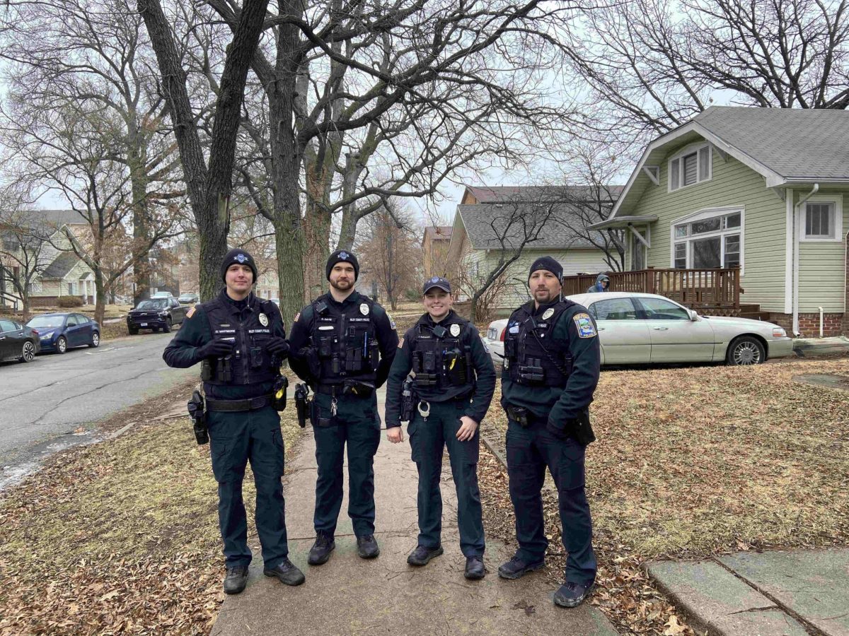 Riley County Police Department officers (left) Gage Whitmore, Dakota Davis, Julia Raymann and Carson Lang, knocking on doors along Vattier St. on Feb. 5.