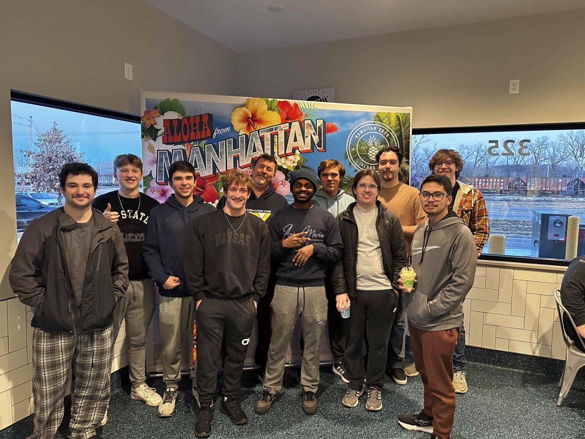 Kansas State students pose in front a marketing poster at Hawaiian Bros Island Grill in Manhattan, KS on Feb. 22 (Photo courtesy of Noah Biswell) 