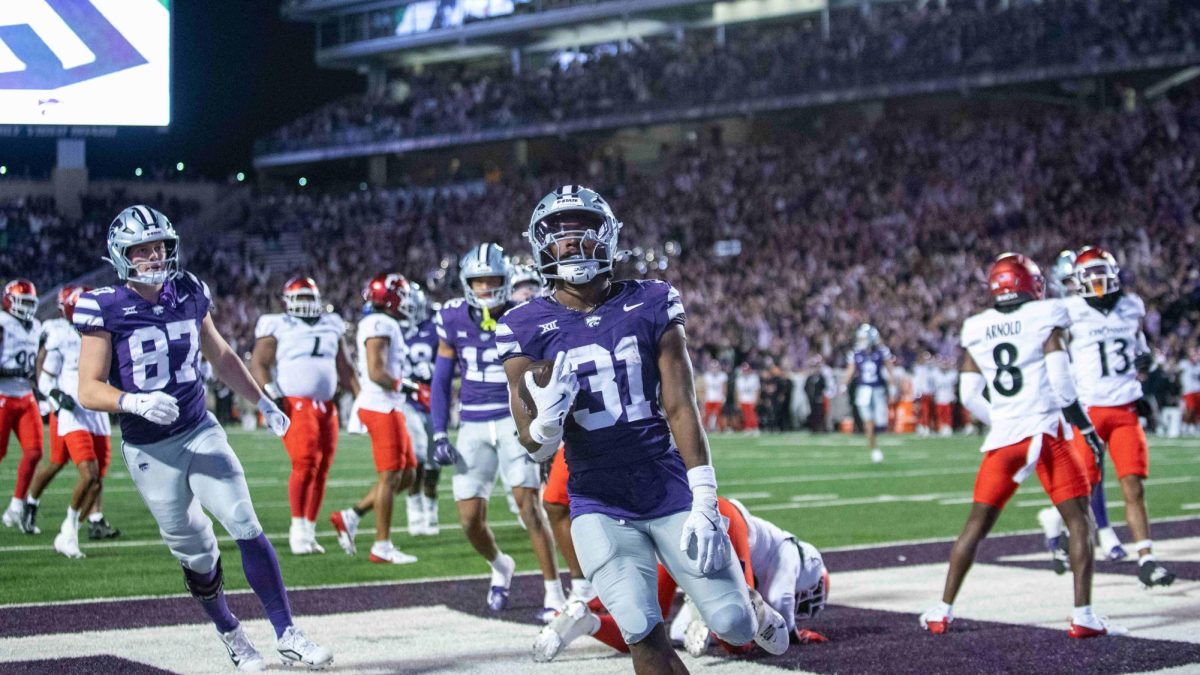 Runningback DJ Giddens celebrates after bursting into the end zone for his first touchdown of the night against Cincinnati on Nov. 23. Giddens led the Wildcats on offense with 143 yards of rushing, 39 receiving yards, and two touchdowns  against Cincinnati in his final career game at Bill Snyder Family Stadium.