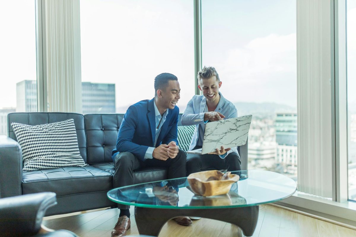 a man and a woman sitting on a couch looking at a map