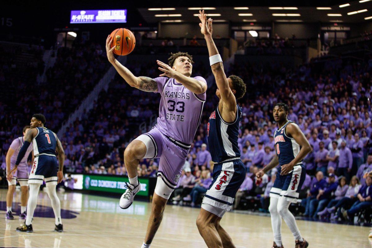 K-State senior forward Coleman Hawkins shoots the ball over an Arizona defender as the Wildcats continued their winning streak to six games with a 73-70 win over Arizona on Feb. 11 at Bramlage Coliseum.

