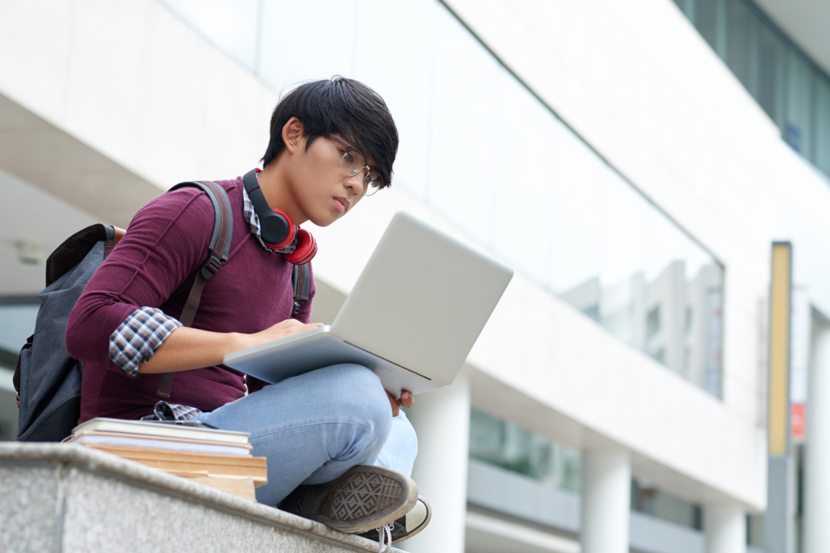A student with a laptop and books