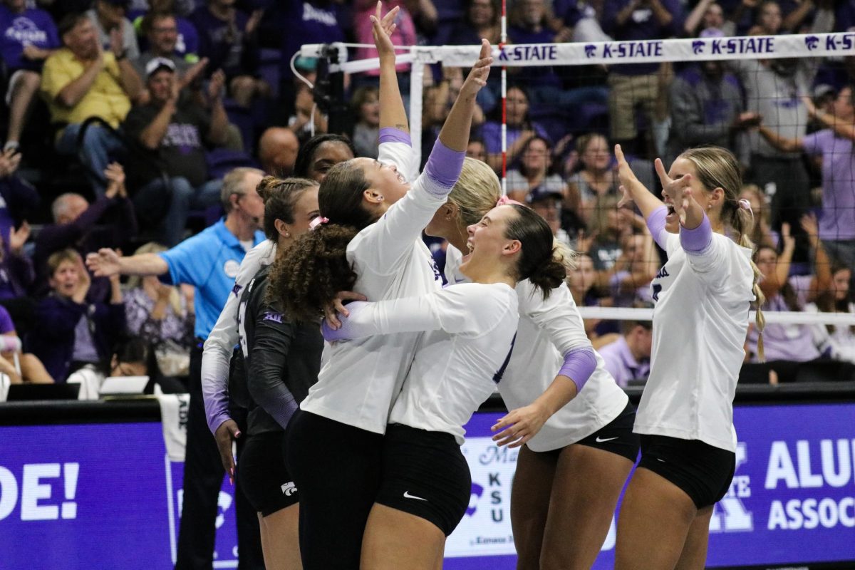 The K-State volleyball team comes together in celebration after gaining a point. The wildcats secured a 3-0 win against BYU on October 26th in the Morgan Family Arena. (Archive Photo by Jersey Johnson | Collegian Media Group)