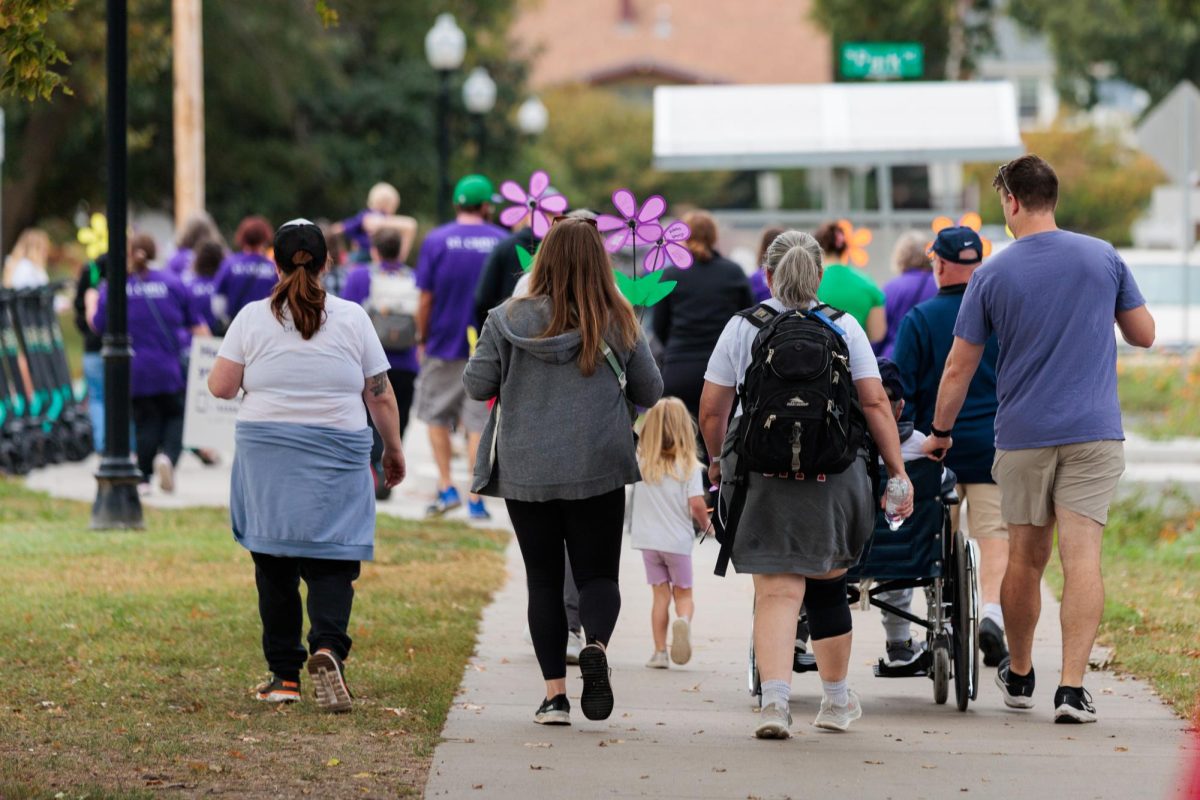Participants in the Walk to End Alzheimer’s walk down a street in city park in Manhattan, KS, on Oct. 18, 2025_