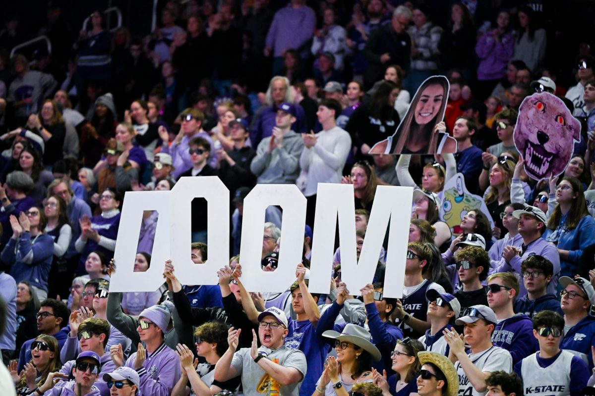Students hold up DOOM signs in the Farmageddon game against Iowa State.  The Wildcats defeated the Cyclones in overtime 87-79. 