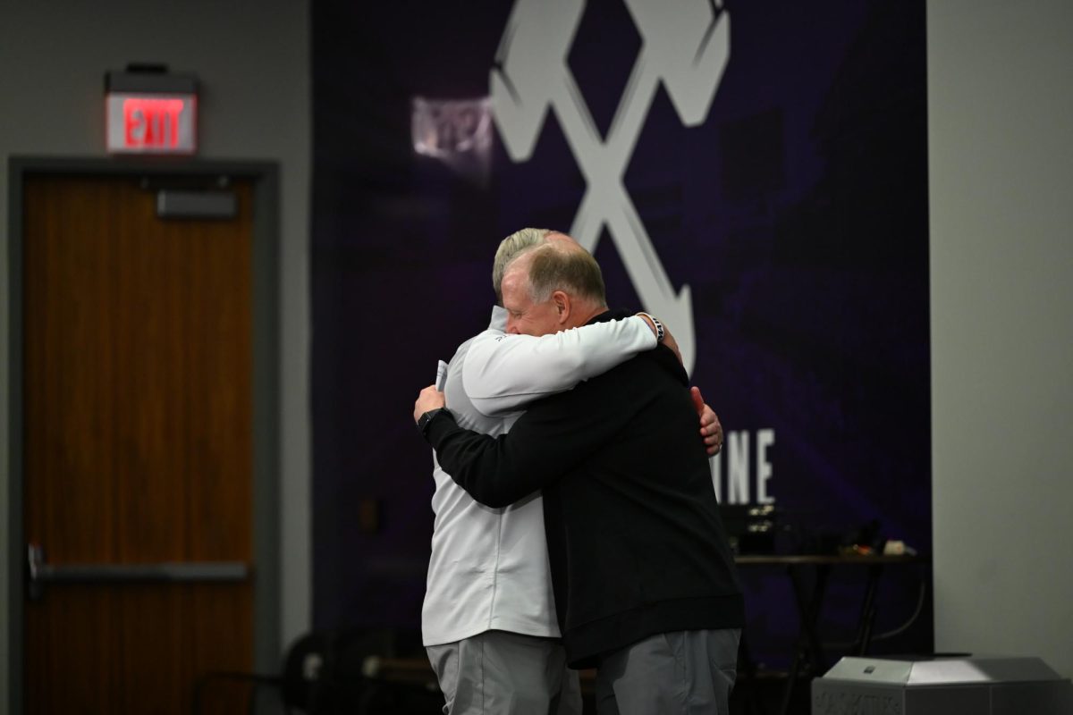 Athletic director Gene Taylor and head coach Chris Klieman hug after press conference announcing Klieman's retirement on Dec. 3. 