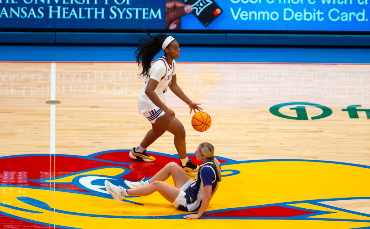 Junior S'mya Nichols drops a Kansas State defender while bringing the ball up the court in the first half. (University Daily Kansan)