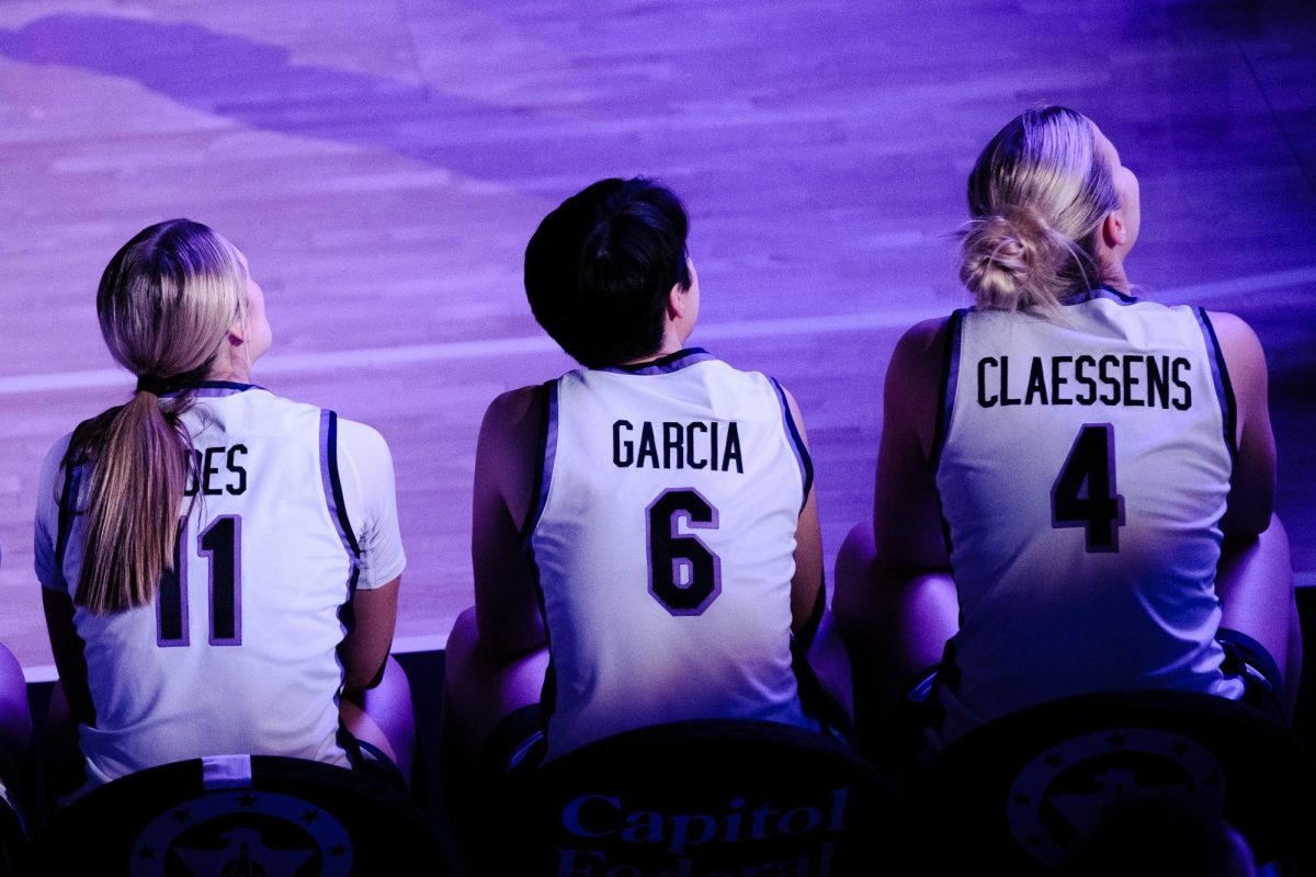 K-State Women's Basketball players Taryn Sides (11), Gina Garcia (6) and Nastja Claessens (4) watch the pregame hype video from the bench prior to their announcement as starters for the January 4, 2026 game against West Virginia at Bramlage Coliseum.