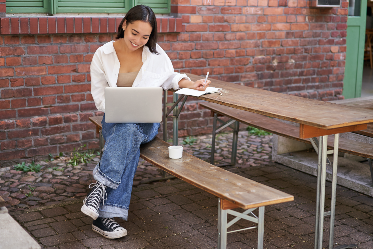 A woman with a laptop and notebook