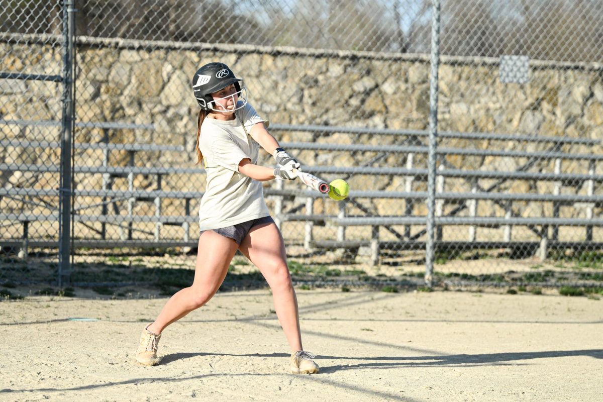 President of the K-State Softball Club Abby Kelley works on hitting during a Sunday evening practice for the spring season. Kelley is a junior at K-State studying management.
