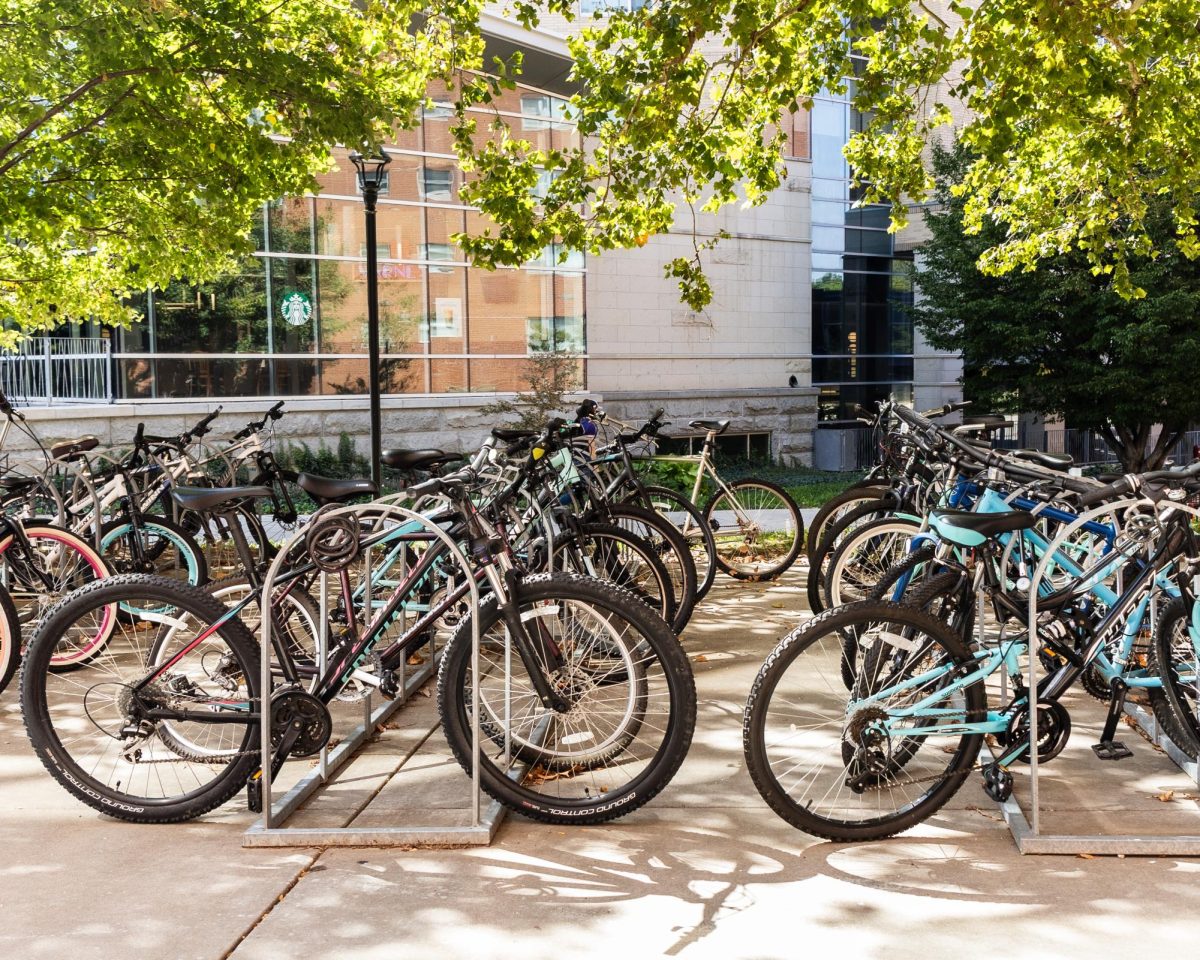 Students' bikes fill the racks outside Goodnow Hall, showing one of the main spots for bike parking on campus.  
