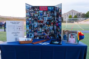 A memorial display for Jack Fleischaker at Memorial Stadium includes a photo board and the word “FLY,” his nickname, across the top. 