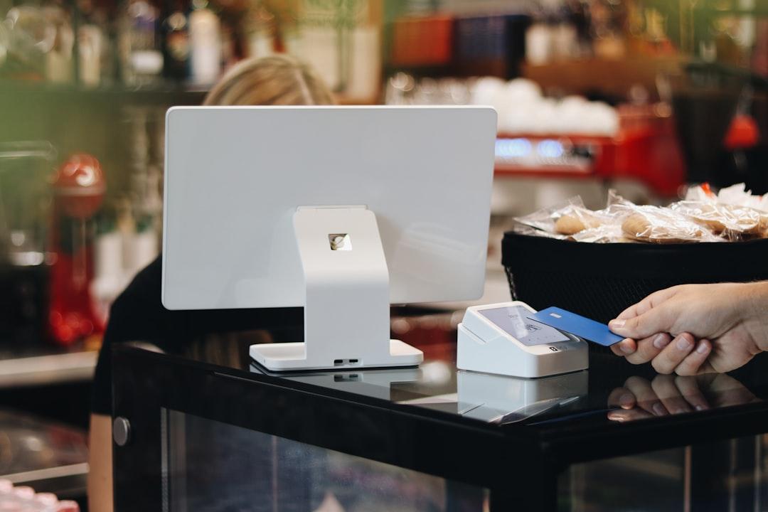 A retail clerk checking a photo id card at a store counter