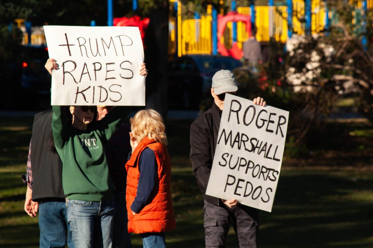 Protesters hold strongly worded signs about political candidates at a "No Kings" protest outside Manhattan City Hall ahead of the upcoming elections.