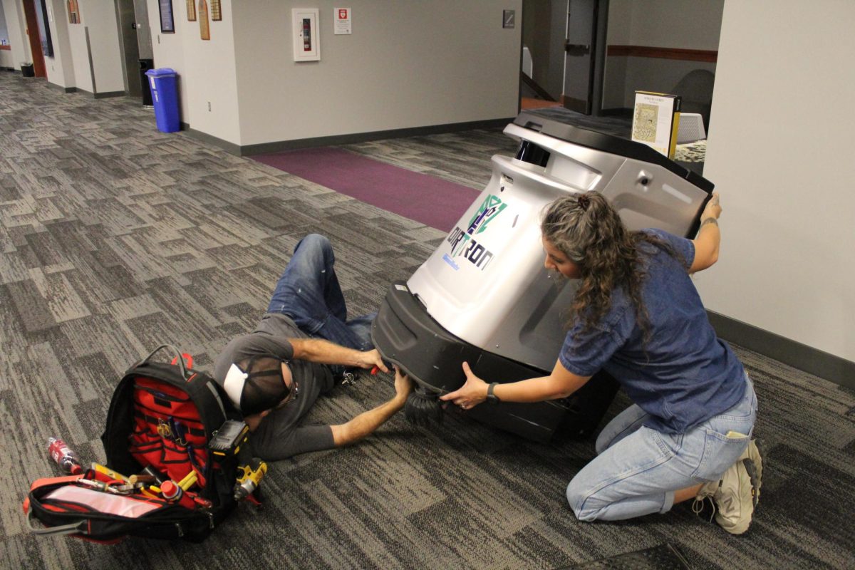 Maintenance workers Jacob Boggs and Danielle Salcedo work together to repair a floor-cleaning machine at the K-State library on Sept. 23.