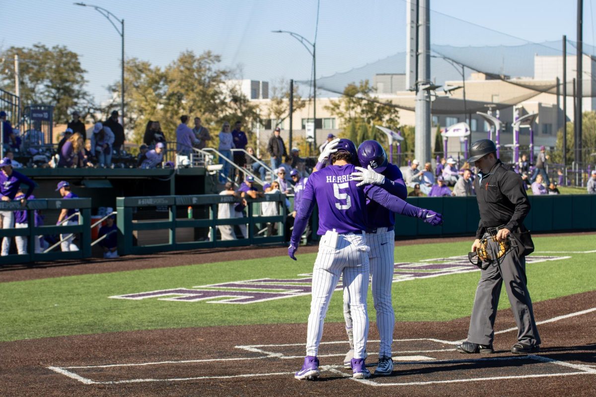 After scoring a run against Kansas, fifth-year Brady Harris celebrates with a teammate on Oct. 17, at Tointon Family Stadium. 