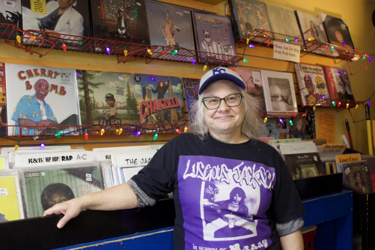 Sarah Cunnick stands in front of a wall of vinyl records at her store Sisters of Sound, also known as SOS, named as a calling card for the music lovers of Manhattan.